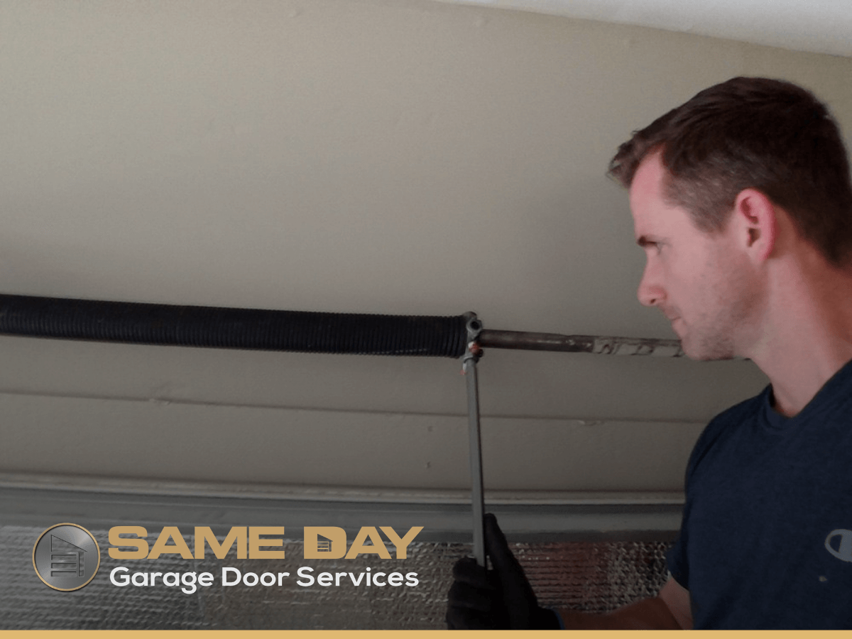 Peter Brown, owner and technician at Same Day Garage Door Services, performs some repairs while inspecting if garage door spring are faulty
